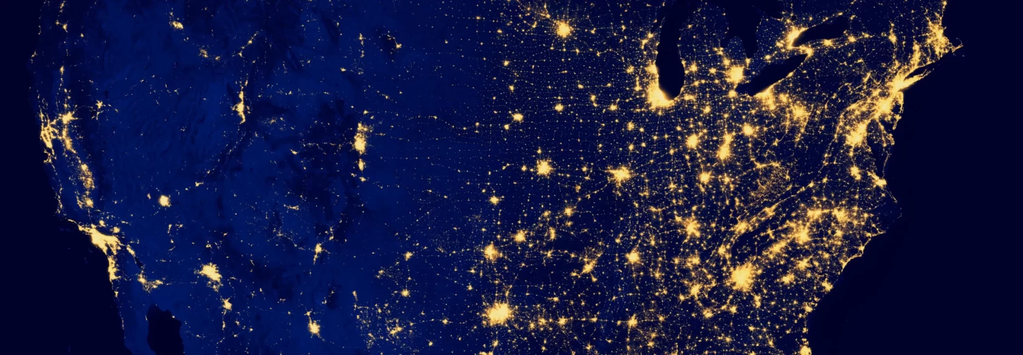 A photograph of the United States taken from outer space showing a concentration of city lights