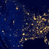 A photograph of the United States taken from outer space showing a concentration of city lights